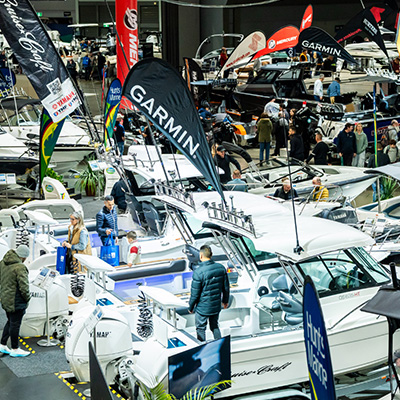 Visitors exploring boats, marine products and exhibitor displays at a boating exhibition